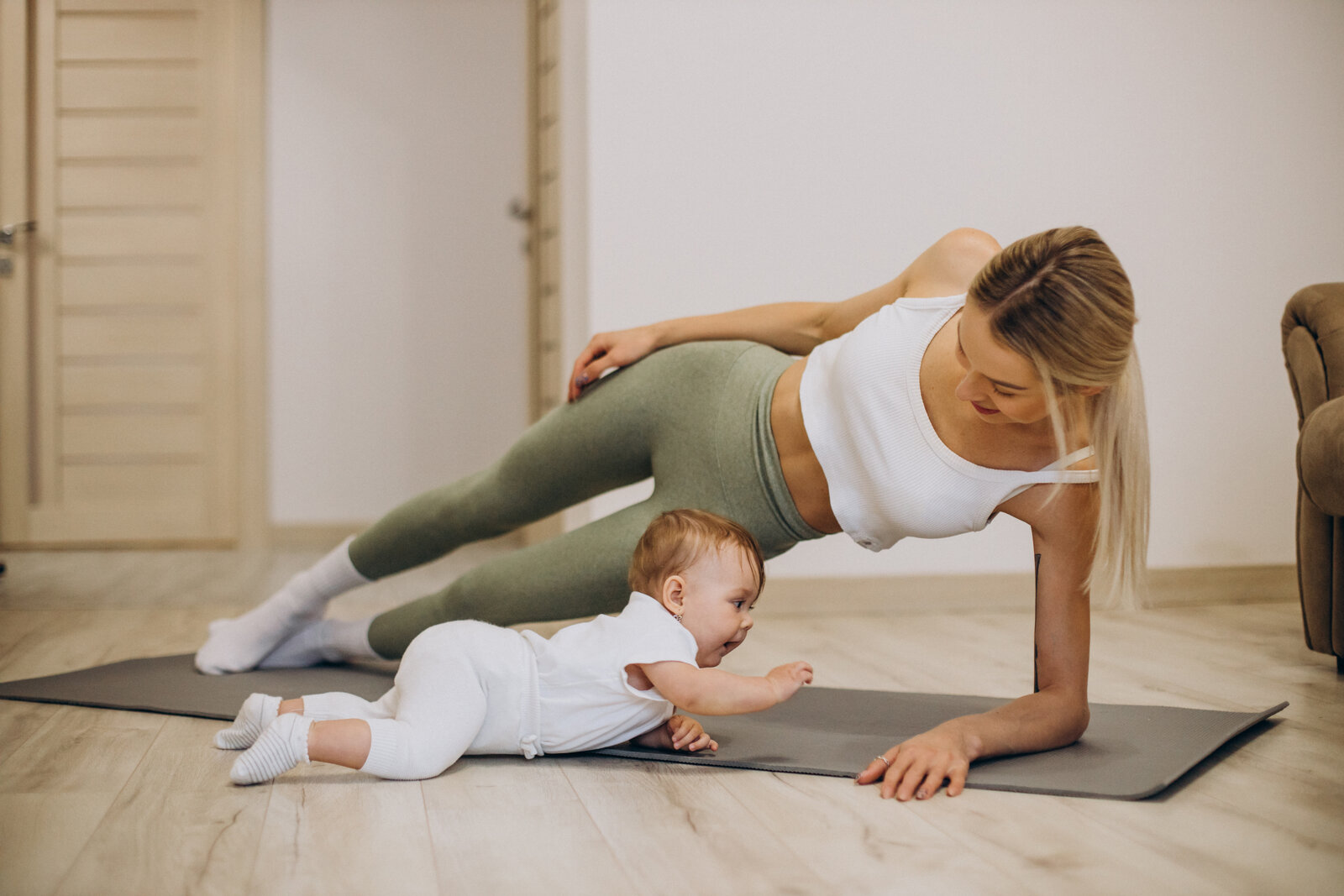 Mère faisant du yoga avec son bébé à la maison