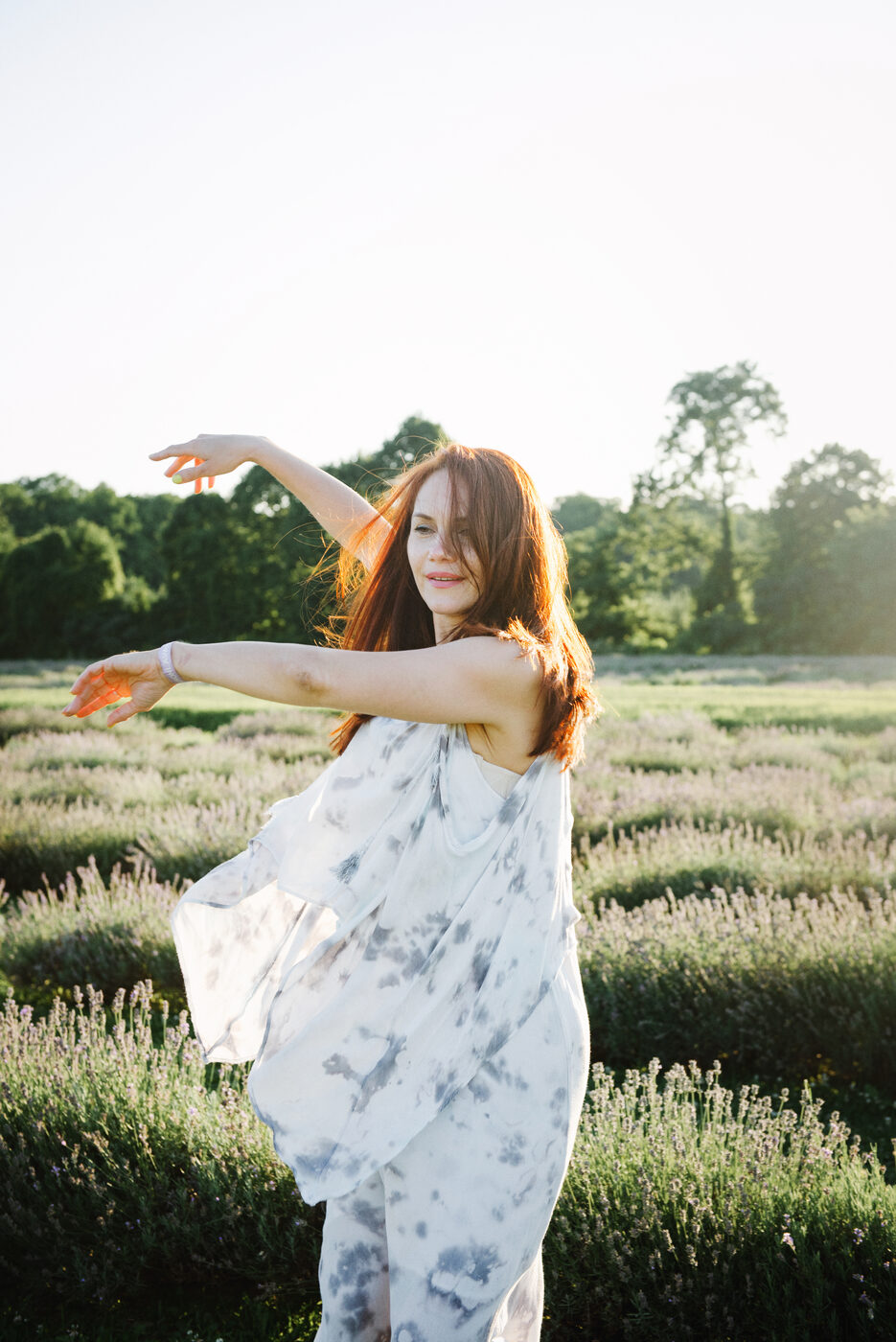 Anna, founder of VitalysFit, joyfully moving in a golden lavender field