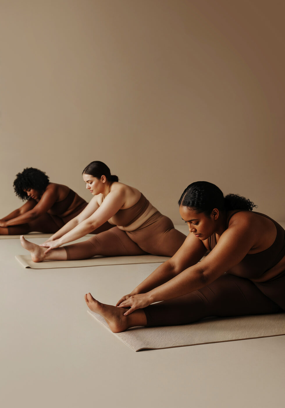 Three women of different bodies and ages stretching together